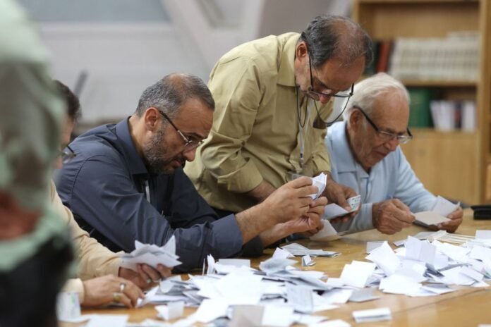 Подсчет голосов после окончания голосования на внеочередных президентских выборах в Иране.